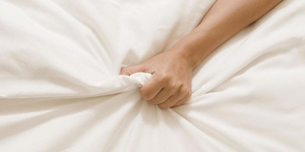 hand grabbing bed sheets